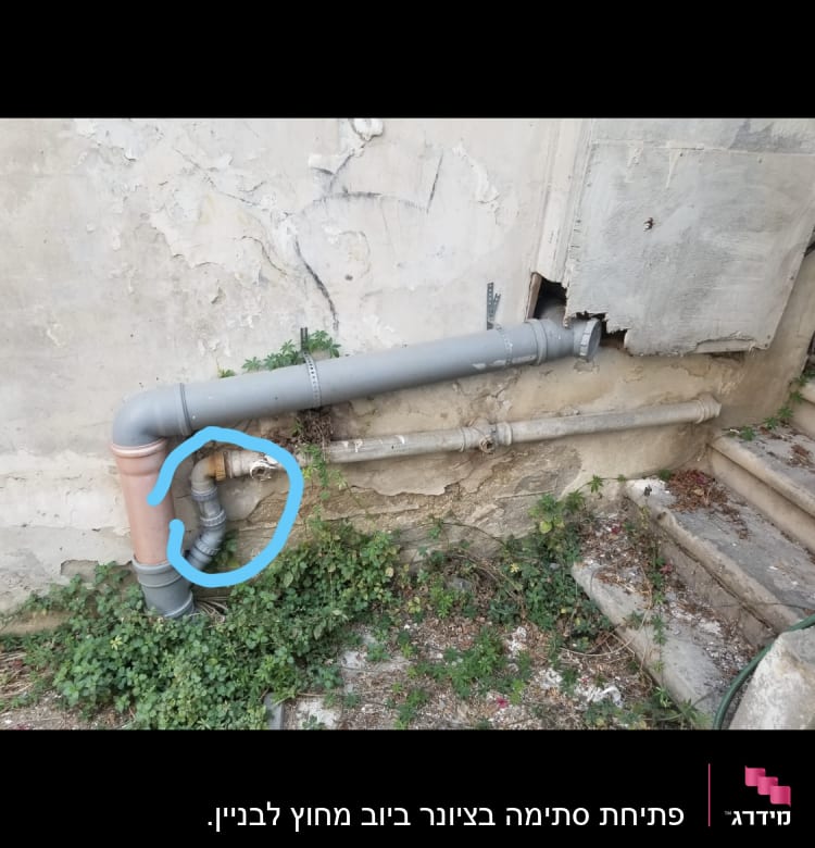 צינור מתכת עם חיבורי פלסטיק על קיר חיצוני